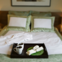 Frisch gemachtes Bett mit Kaffeegedeck