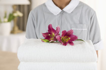 Ein Handtuchpaket, gekrönt mit Blumen, wird gereicht